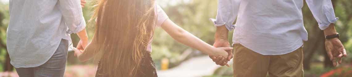 Image of two parents holding their child's hands